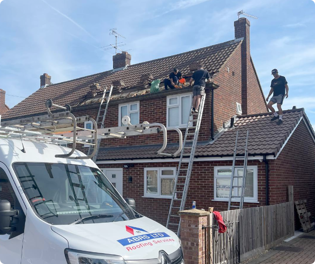 Roofers repairing a tiled house roof